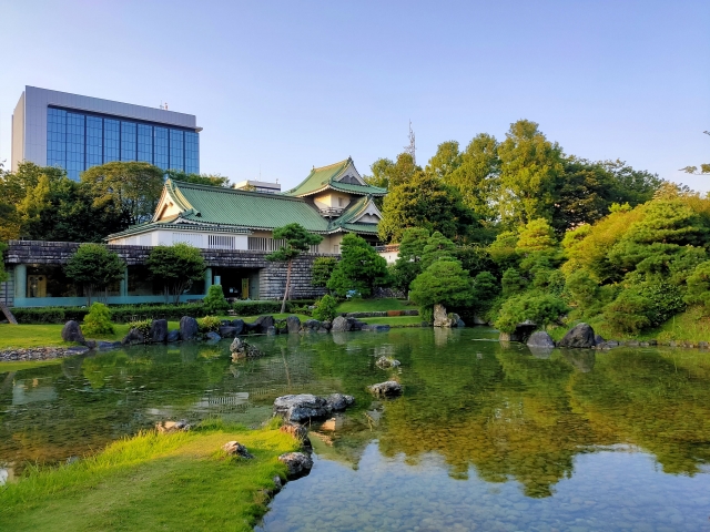 Traditional Japanese-style museum building beside a pond and landscaped garden