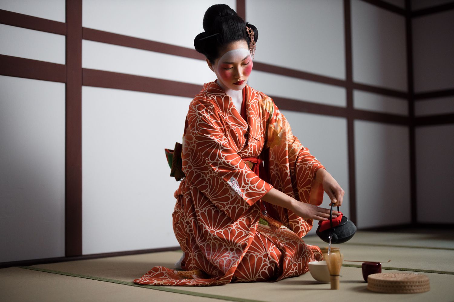 Woman wearing a kimono performing a Japanese tea ceremony
