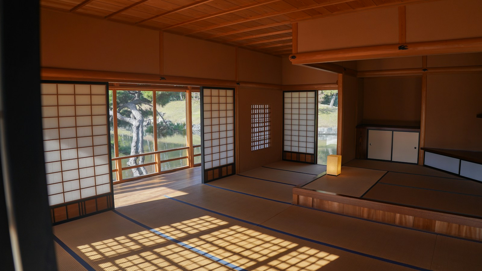 Sunlit traditional Japanese room with shoji screens overlooking a Japanese garden, photographed by Yosuke Ota